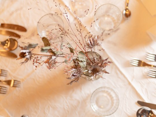 Romance in the mountains Table setting with dried flowers, glasses, and cutlery on a white tablecloth