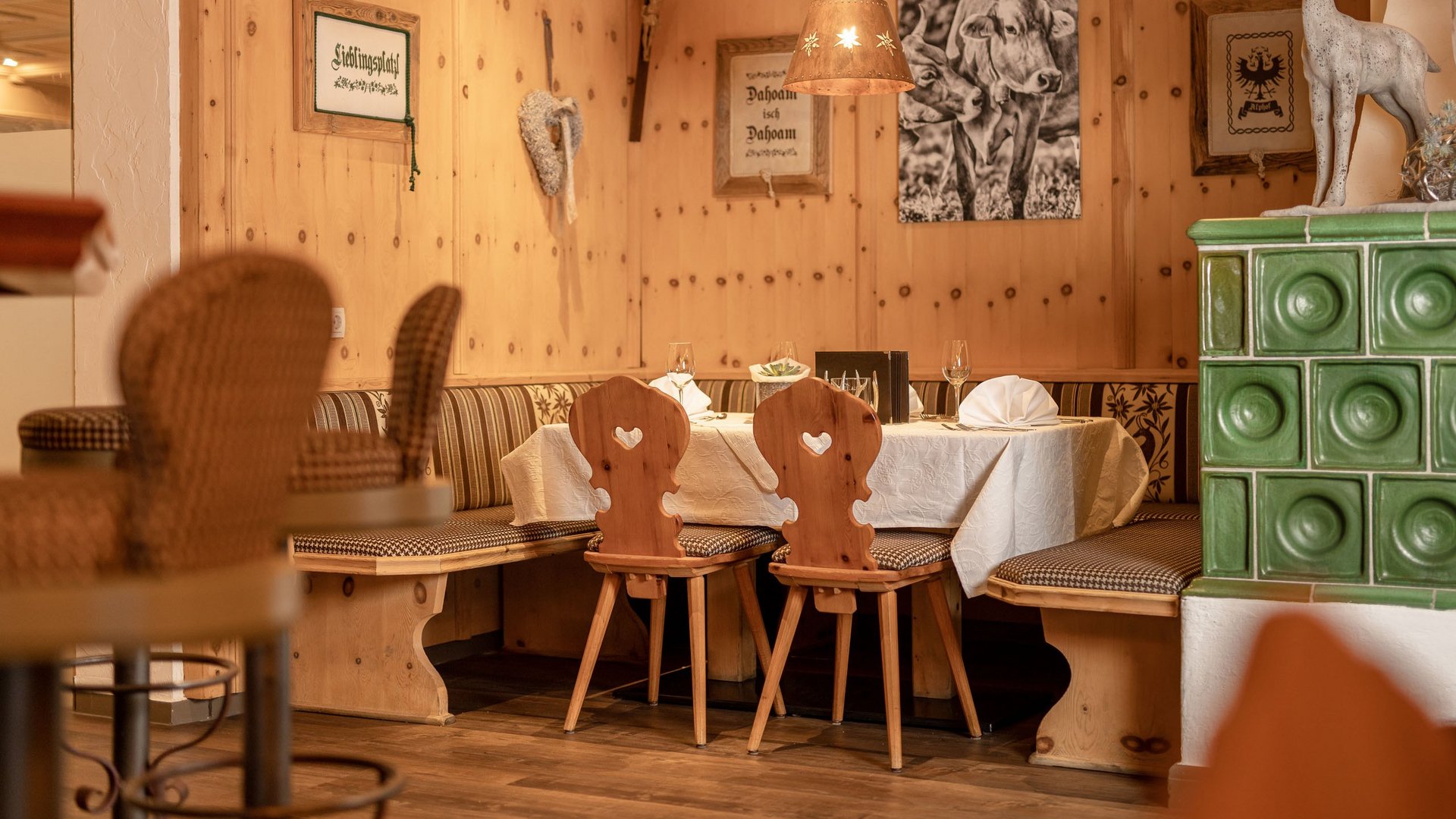 Mein Hotel in Fulpmes im Stubaital Gemütliche Holz-Eckbank mit Tischen, Stühlen und Alpen-Dekoration im Restaurant