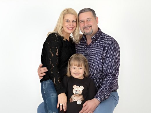 Mein Hotel in Fulpmes im Stubaital Glückliche Familie mit Mutter, Vater und Tochter posiert vor weißem Hintergrund