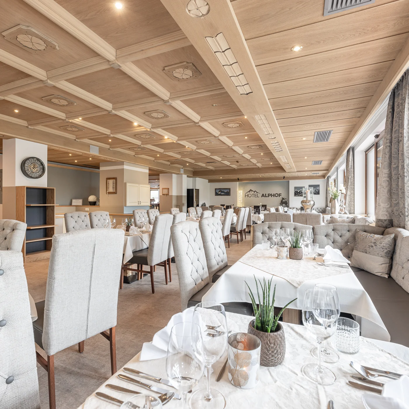 Der Alphof | Ihr Hotel in Fulpmes Heller Speisesaal des Hotels Alpbach mit gedeckten Tischen und Polsterstühlen