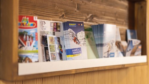 Mein Hotel in Fulpmes im Stubaital Verschiedene touristische Broschüren und Flyer in einem Holzregal