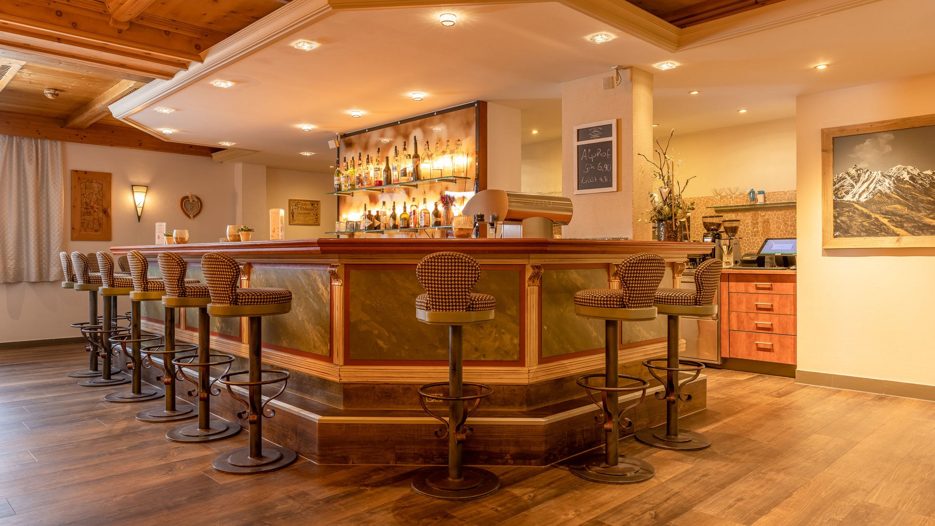 Stubaital: family hotel for holidays in comfort Bright wooden bar area with bar stools and illuminated bottles