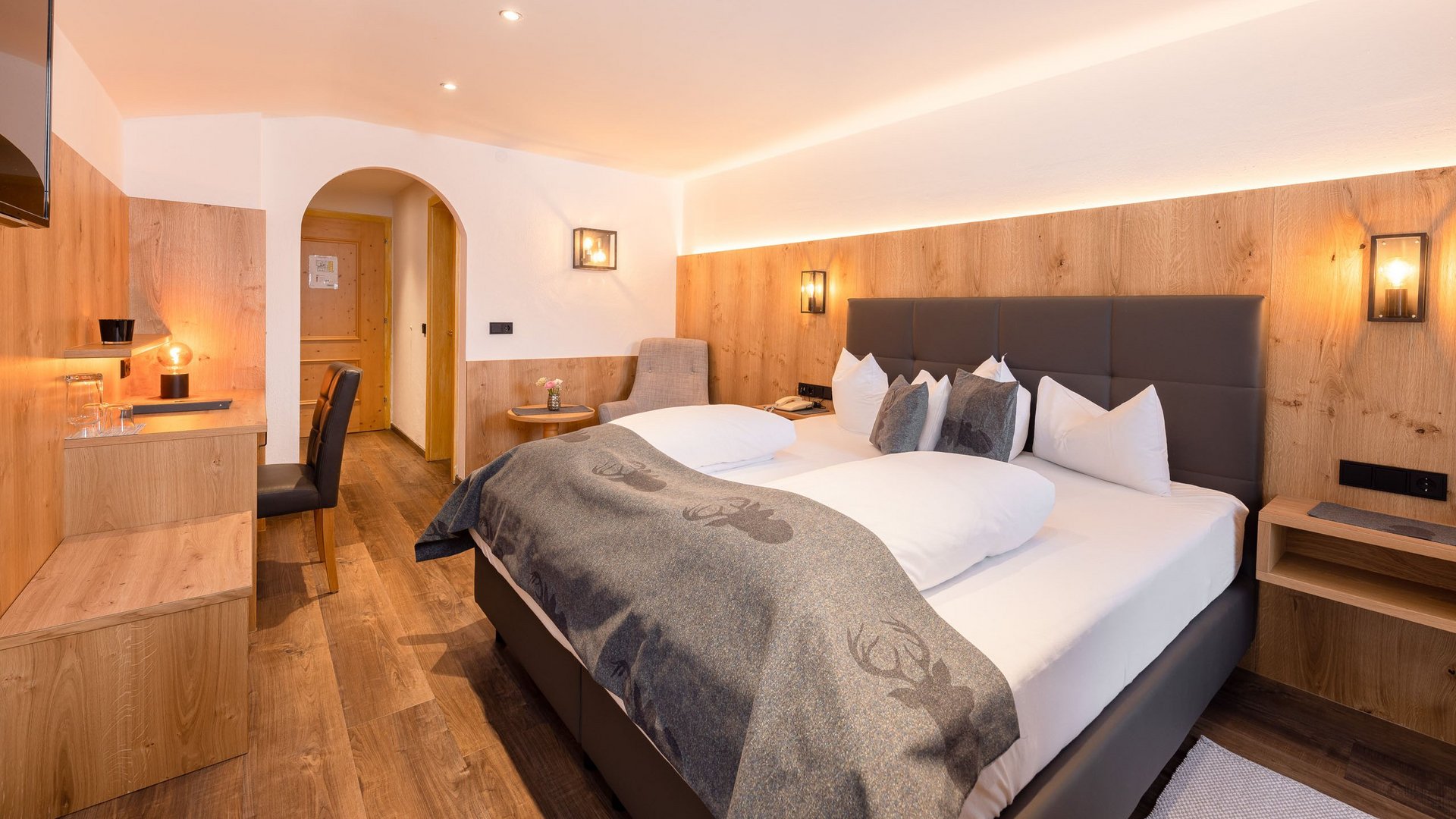 Mein Hotel in Fulpmes im Stubaital Modernes Hotelzimmer mit Doppelbett, Holzverkleidung und TV