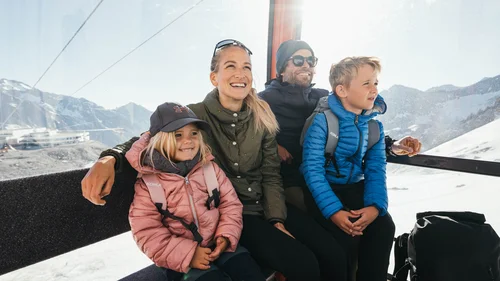 Der Alphof | Ihr Hotel in Fulpmes Familie in einer Seilbahnkabine mit verschneiten Bergen im Hintergrund