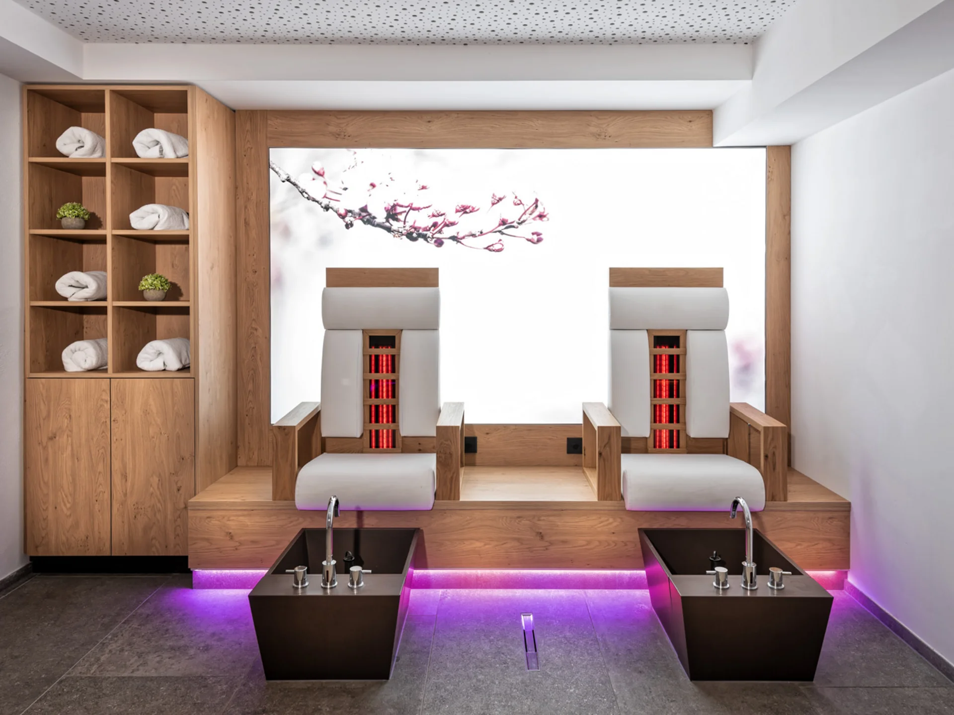 Der Alphof | Ihr Hotel in Fulpmes Moderner Wellnessraum mit zwei beheizten Liegen, Fußbecken und Handtuchregal