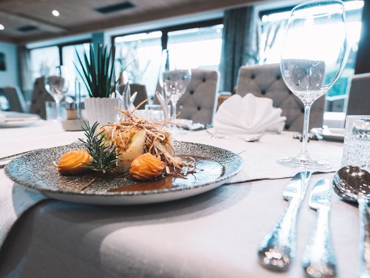 Mein Hotel in Fulpmes im Stubaital Gourmetgericht kunstvoll auf grauem Teller bei feinem Tischgedeck