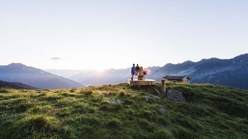 Mein Hotel in Fulpmes im Stubaital Zwei Personen auf Holzbank mit Alpenblick im Sonnenuntergang